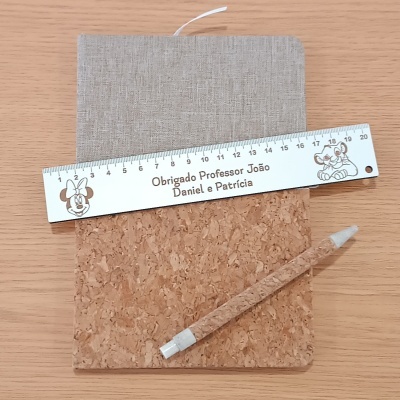 Conjunto com régua, caderno e lápis sobre mesa de madeira