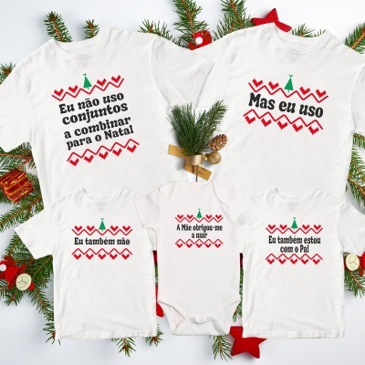 T-shirts e body brancos com estampados e textos de Natal em português numa decoração natalícia com ramos de pinheiro.