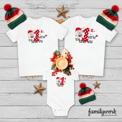 roupas brancas com tema natal pai, mãe e bebé com gorros vermelhos e verdes sobre madeira cinzenta
