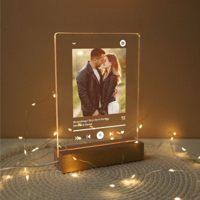 Moldura de acrílico com imagem de casal e texto musical em base de madeira com luzes