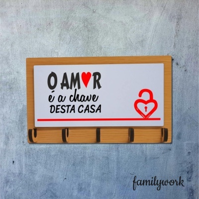 Organizador de parede para chaves em madeira com placa decorativa e ganchos.