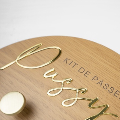 Prato de madeira com letras douradas e texto KIT DE PASS impresso