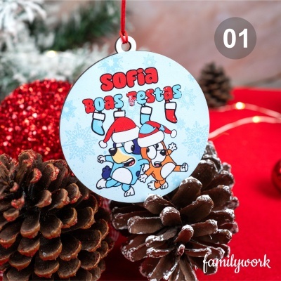 Ornamento de Natal redondo azul claro com personagens animadas e texto em vermelho e azul