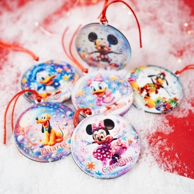 Ornamentos redondos Disney com fitas vermelhas e personagens coloridos em fundo branco e vermelho
