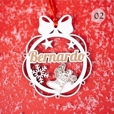 Enfeite natalício de madeira com o nome Bernardino, laço branco e motivos de Natal, pendurado com fita vermelha sobre fundo vermelho com neve.
