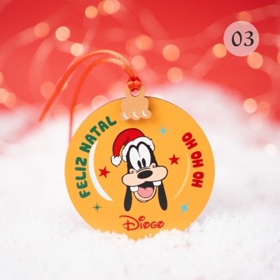 Etiqueta redonda de papel com ilustração de Natal do Pateta e texto, sobre neve com fundo vermelho