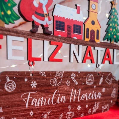 Decoração de Natal de madeira com figuras e texto personalizado.