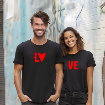 Casal sorridente com t-shirts pretas e letras vermelhas LV e VE no peito em fundo urbano grafitado.