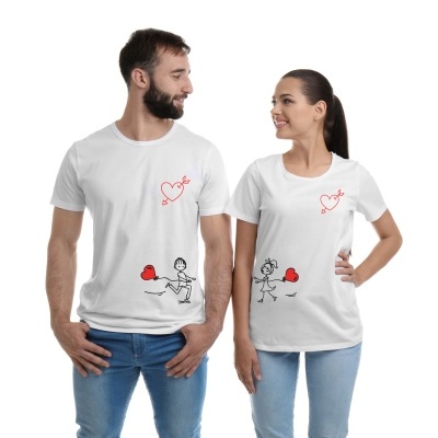 Duas pessoas de t-shirts brancas com estampados de corações vermelhos e desenhos a preto.