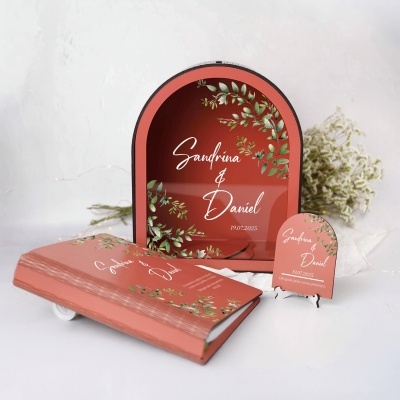 Convite de casamento em papel cor de salmão com design de folhagens verdes e texto em branco