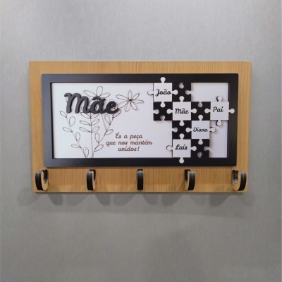 Cabideiro de parede em madeira com desenho floral e peças de puzzle com nomes