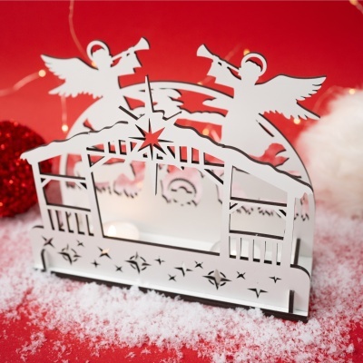 Decoração natalícia em metal branco com anjos e estrela sobre fundo vermelho e neve artificial