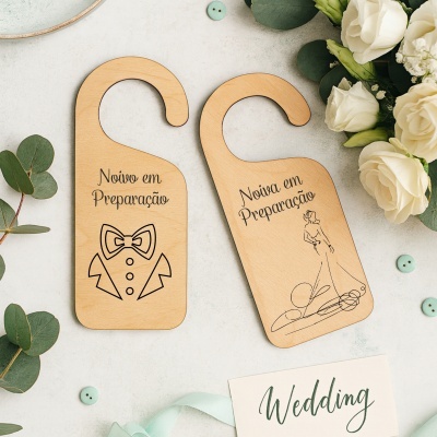 Duas placas de madeira claras para portas com texto e desenhos relacionados a noivo e noiva, flores e folhas ao fundo.