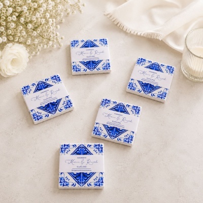 Azulejos quadrados azuis e brancos com etiqueta de casamento junto a flores e vela