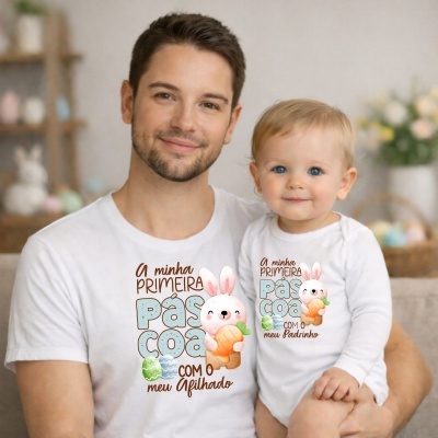 Pai e bebé com t-shirts brancas decoradas com coelho e textos de Páscoa.