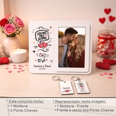 Moldura branca com foto de casal e texto JUNTOS PRA SEMPRE, vela acesa, flores em jarro e dois porta-chaves na mesa