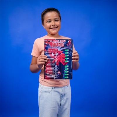 Criança feliz a segurar quadro de tarefas do Homem-Aranha.
