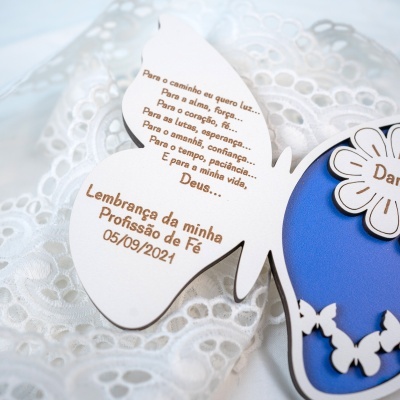 Cartão em forma de borboleta com texto em madeira sobre renda branca