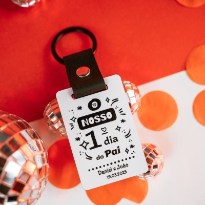 Chaveiro com etiqueta branca e argola preta em fundo vermelho com pontos laranja