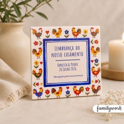Placa decorativa com galos coloridos e texto em português comemorativo de casamento, ao lado de um vaso creme e uma vela acesa.
