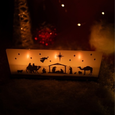 Lanterna decorativa com cena da Natividade em cor laranja iluminada num ambiente escuro