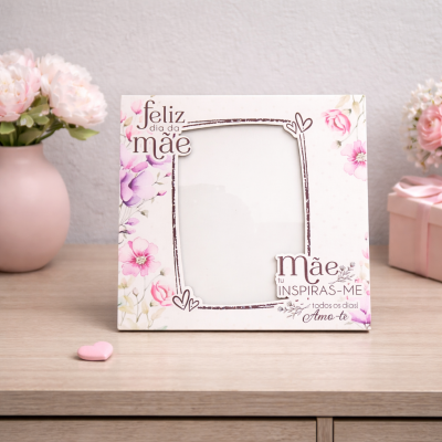 Moldura decorativa com flores e texto para o dia da mãe sobre mesa de madeira.