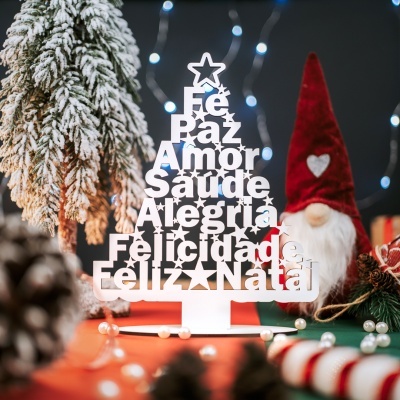 Decoração de Natal em forma de árvore branca com palavras recortadas e estrela no topo