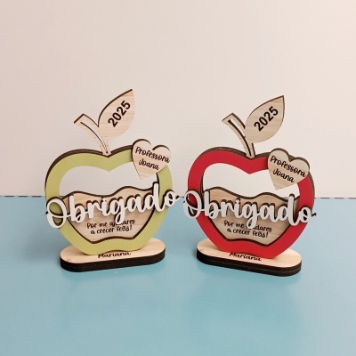 Objetos decorativos de madeira em forma de maçã com texto Obrigado e nomes personalizados.