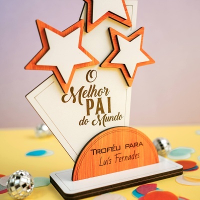 Trofeu decorativo de madeira com estrelas e texto O Melhor PAI do Mundo num ambiente festivo