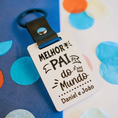 Porta-chaves com texto MELHOR PAI do Mundo sobre fundo azul com círculos coloridos.