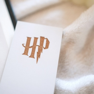 Cartão branco com marca HP em castanho sobre tecido branco felpudo