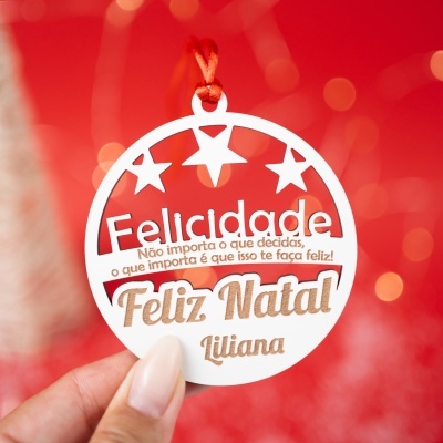 Etiqueta redonda branca pendurada com fita vermelha e texto de Natal