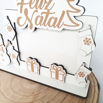 Decoração natalícia em madeira com texto feliz natal e desenhos de meias e presentes