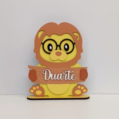 Figura decorativa de leão a segurar cartaz com o nome Duarte
