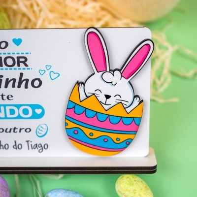 Livro infantil com desenho de coelho dentro de ovo colorido e texto em português