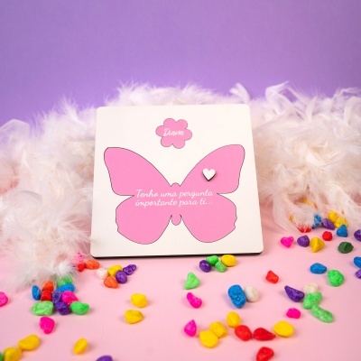 Cartão decorativo com borboleta rosa e penas brancas ao fundo