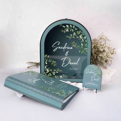 Conjunto de convite, espelho e cartão decorativo azul-acinzentado com folhas verdes e texto para evento