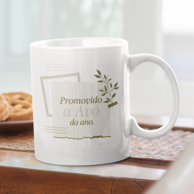 Caneca branca com impressão verde Promovido a Avô do ano. sobre uma mesa de madeira.