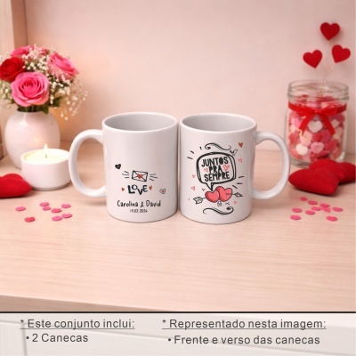 Duas canecas brancas com texto e decoração de corações e amor, rodeadas de decoração romântica de flores, vela e corações