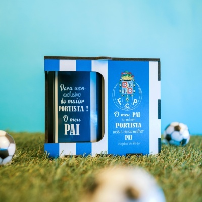 Caixa de presente azul e branca com caneca azul e escudo do FC Porto sobre relva artificial