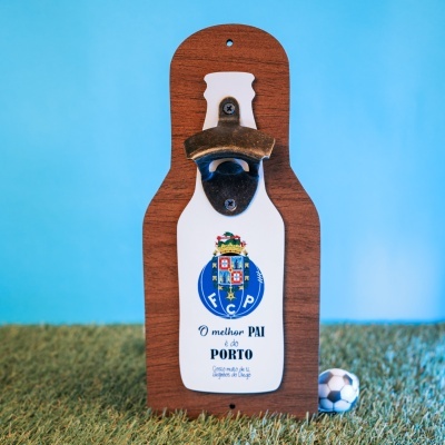 Abridor de garrafas com base de madeira e placa branca com símbolo FC Porto e texto, bola de futebol miniatura ao lado.