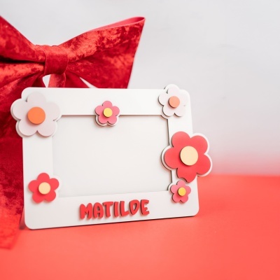 Moldura branca decorada com flores coloridas e nome MATILDE em letras vermelhas