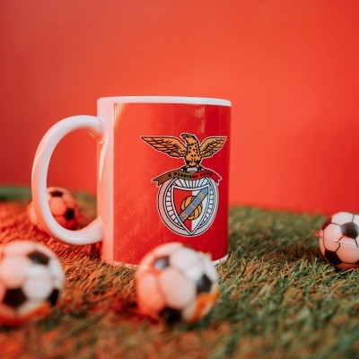 Caneca branca do SL BENFICA com bolas de futebol em miniatura sobre relva artificial