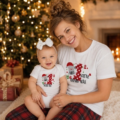 Mãe e bebé com roupa natalícia branca decorada com motivos alusivos ao 1º Natal.
