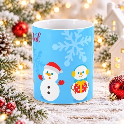 Caneca azul com desenhos de bonecos de neve e flocos de neve em cenário natalício.