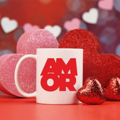 Caneca branca com texto vermelho AMOR e corações brilhantes vermelhos e rosas ao redor