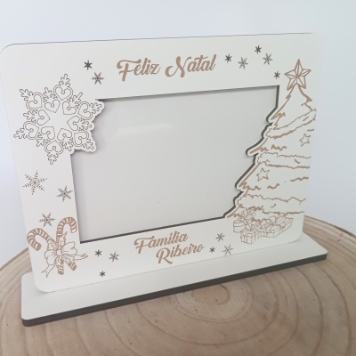 Moldura de madeira branca com decoração dourada e texto Feliz Natal