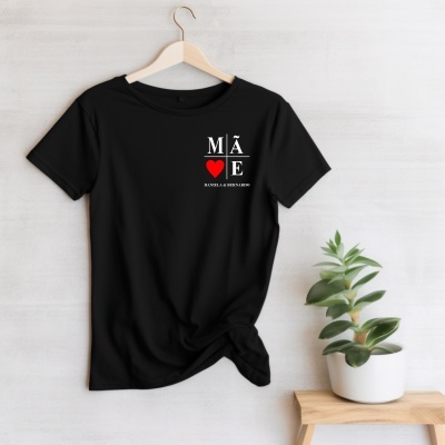 T-shirt preta com impressão para mãe pendurada num cabide com planta ao lado