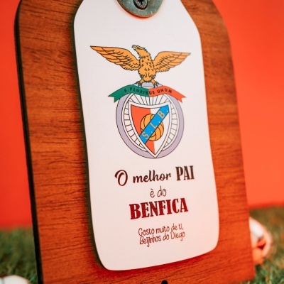 Placa de madeira com etiqueta do Benfica e texto em português.