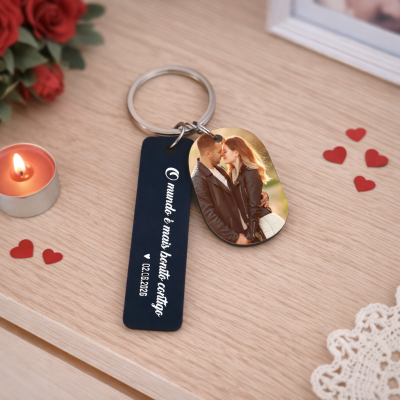 Porta-chaves com pendente azul com texto e pendente com foto de casal, sobre superfície de madeira com decoração de corações e vela